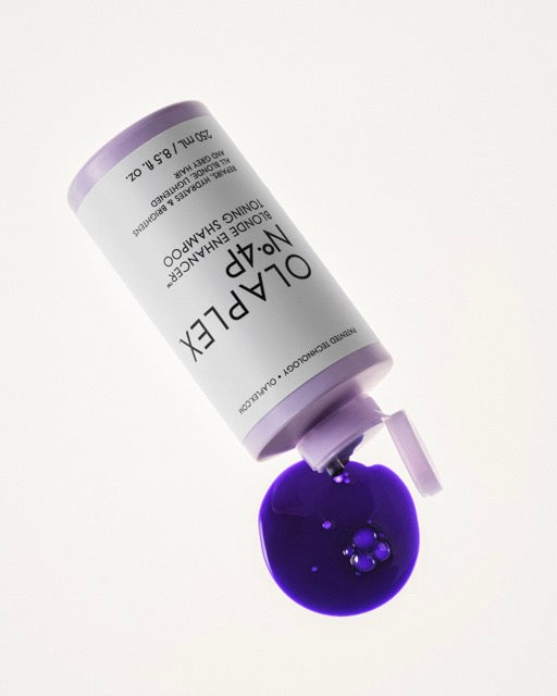 Bottle of No.4P laid on its side with purple shampoo spilling out