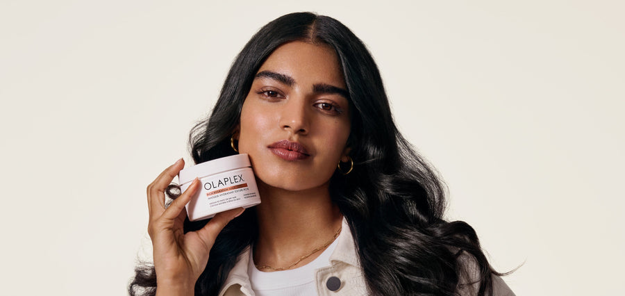 Brunette woman holding OLAPLEX Rich Hydration Mask