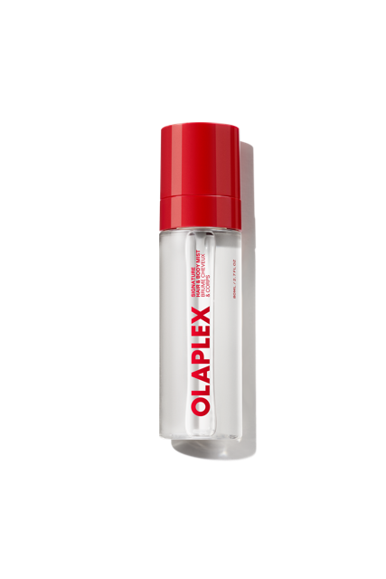 A clear bottle of Olaplex Hair and Body Fragrance Mist featuring a vibrant red cap and the bold Olaplex logo printed vertically down the front, shown against a transparent grid background. - main view